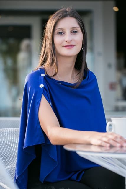 Elegant woman in a royal blue dress sitting outdoors, showcasing stylish fashion for women, modern casual wear, and sophisticated summer outfit ideas for women.