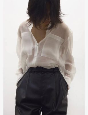 Silk white button-up blouse with chest pockets, black high-waisted leather pants, minimalist fashion look, designed by katyamaker, stylish women's clothing, modern outfit inspiration.