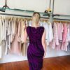 Elegant woman shopping for feminine dresses in a boutique, showcasing stylish pink, white, and beige clothing, perfect for fashion enthusiasts interested in trendy women’s apparel.