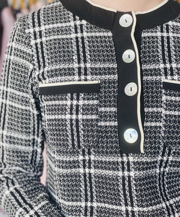 Stylish black and white plaid tweed jacket with pearl-like button accents, contrasting trim, and tailored fit, perfect for sophisticated casual or office wear.