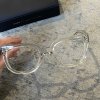 Clear fashionable designer eyeglasses with a thick transparent frame and a black Marc by Marc Jacobs box in the background.