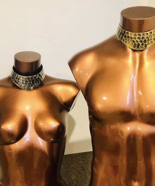 Shiny metallic mannequin torsos with gold and bronze finish showcasing jewelry displays for jewelry, fashion accessories, jewelry display mannequins for designer jewelry, artistic jewelry presentation, modern jewelry showcase design.
