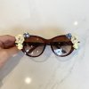 Fashion sunglasses with floral embellishments, brown tinted lenses, stylish accessories for women, summer eyewear, designer sunglasses.