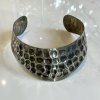 Polished silver statement cuff bracelet with a textured hexagonal pattern artisan jewelry handmade jewelry.