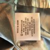 Silky satin fabric with care label indicating hand washing, gentle drying, and ironing instructions, made in China, representing luxurious textile craftsmanship.