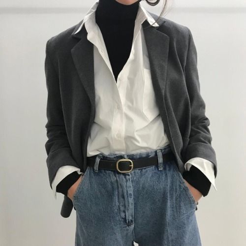 Stylish professional woman in a dark blazer, white shirt, and high-waisted jeans, showcasing modern office fashion and business casual outfit ideas for women.