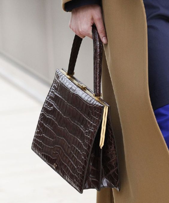 Luxury leather handbag with crocodile texture, gold accents, and sturdy handle, perfect for elegant fashion and everyday style.