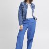 Bright blue tailored high-waisted trousers with a relaxed fit, paired with a casual white t-shirt and classic denim jacket for a stylish, versatile look.