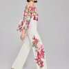 Vibrant floral designer outfit featuring a pink and green botanical print on a flowy top and wide-leg pants, perfect for spring and summer fashion statements.