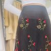 Vibrant black skirt with intricate embroidered red, green, and beige floral pattern, perfect for stylish occasions, showcasing designer craftsmanship and embroidered detailing at Katyamaker.com.