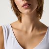 Elegant portrait of a woman with short auburn hair, natural makeup, wearing a white sleeveless top, highlighting beauty and fashion, against a plain background.