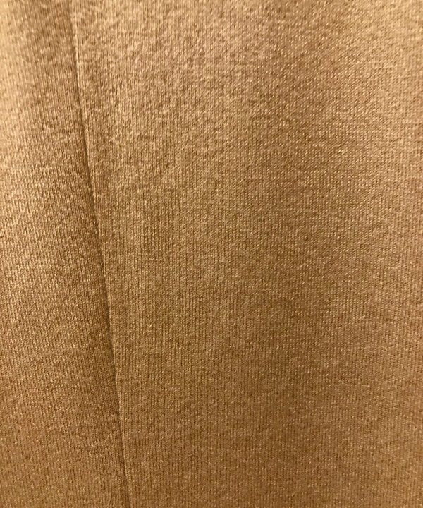 Soft beige knitted fabric texture in close-up.