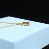 Delicate gold necklace with small padlock pendant on a light blue jewelry box, showcasing minimalist jewelry design and luxurious accessories for women.