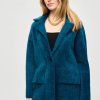 Soft teal fuzzy coat with oversized collar and large front pockets, styled with a black top and gold chain necklace, showcasing cozy winter fashion for women.