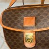 Luxury designer handbag, Celine Paris monogram pattern, brown and tan leather accents, gold hardware, stylish and high-end fashion accessories, women's handbag for elegant occasions.