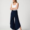Flowy navy blue wide-leg pants and white sleeveless top with square neckline, stylish modern women's fashion, elegant professional look, Katyamaker interior design inspiration.
