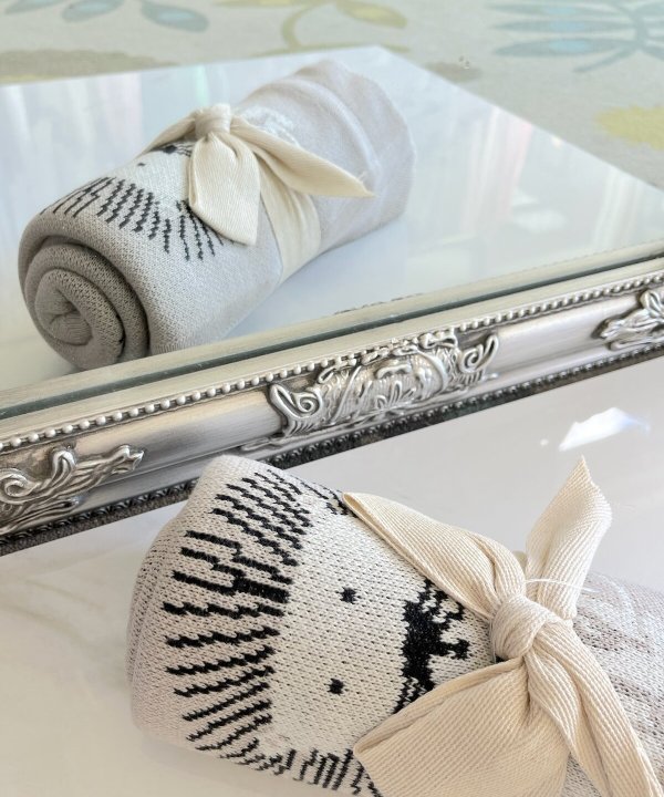 Knitted sock with reindeer design and bow, decorative home décor, cozy winter accessory, handcrafted holiday gift, stylish wool sock, black and white knit sock, festive winter decor, craft showcasing, holiday season accessory, seasonal home decoration, charming textile gift, handmade sock craft, winter-themed home accent, cozy holiday gift idea, Scandinavian inspired knitwear, artistic sock design, seasonal craft, winter décor accessory, reusable festive gift, handmade textile art.