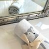 Soft gray and cream sock with adorable animal design, featuring a cute puppy illustration, tied with a beige bow, perfect for cozy home decor or gift-giving, displayed near a decorative mirror.