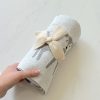 Hand-knit baby blanket with adorable deer design and cream-colored bow, perfect for nursery decor and baby gift ideas.
