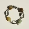 Handmade gemstone and silver bracelet featuring earthy tones, unique stone beads, and modern metal links, perfect for artisanal jewelry enthusiasts.