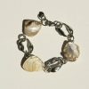 Pearl shell jewelry bracelet with large, irregularly shaped white pearls and chunky silver chain links on a white background.