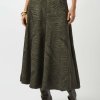 Elegant botanical-print maxi skirt in olive green, styled with knee-high dark leather boots for a chic, sophisticated look. Perfect for fashion-forward outfits and outdoor events.