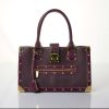 Luxurious purple leather designer handbag with gold hardware and stud accents, perfect for high-end fashion and accessories.