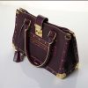 Luxury purple leather handbag with gold accents and studs, stylish designer bag for women, high-end fashion accessory, handcrafted leather purse, designer tote for everyday use.