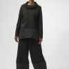 Elegant black fashion outfit featuring a modern oversized top with a cowl neckline and wide-leg pants, perfect for contemporary style and versatile for various occasions.