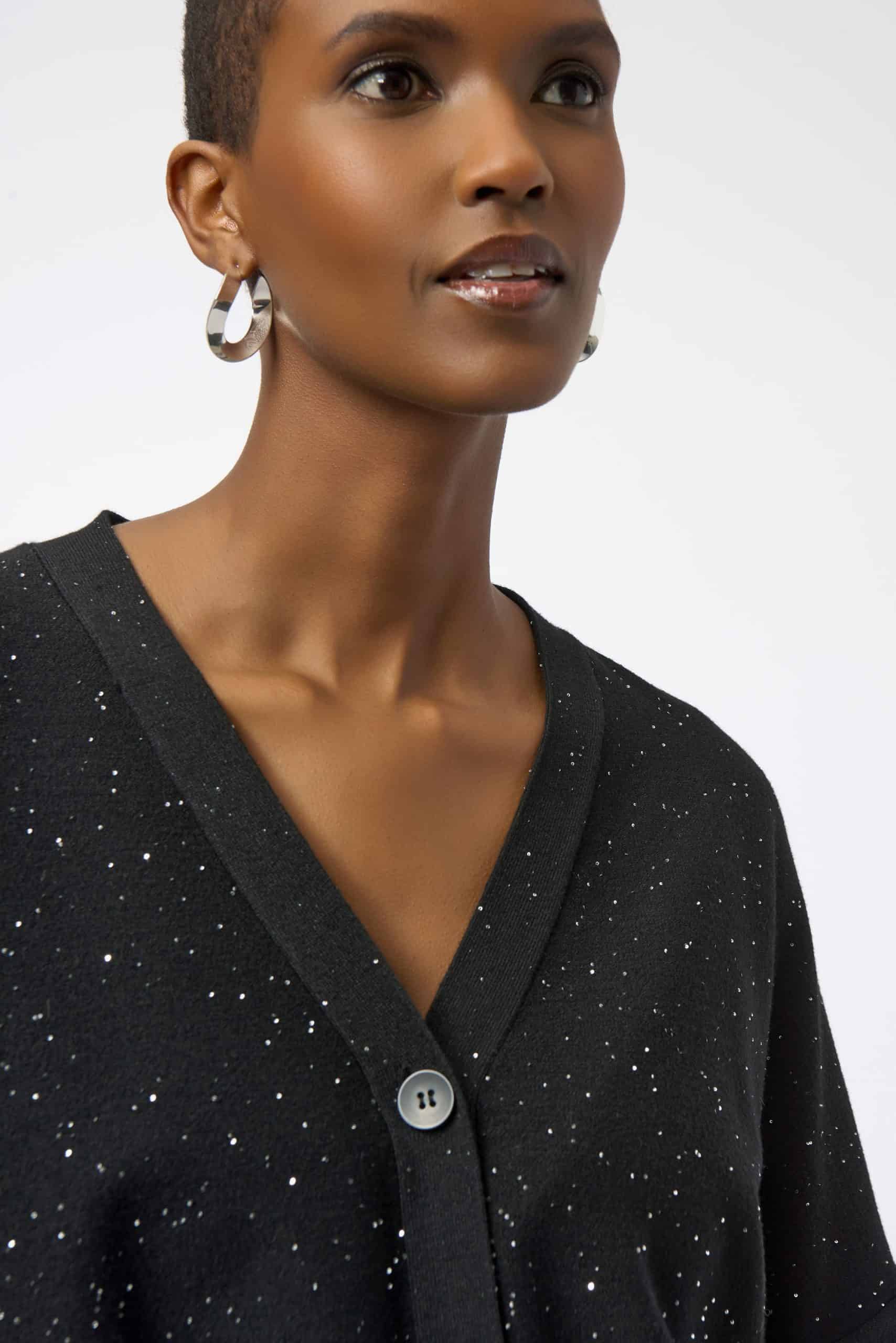 Elegant woman wearing a black speckled cardigan, showcasing stylish jewelry and modern fashion accessories, perfect for fashion-forward looks and everyday wear.