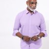 Elegant senior man wearing a lavender dress shirt, glasses, and stylish accessories, posing for a professional photoshoot for Katya Maker, emphasizing fashion, style, and confidence in men’s apparel.